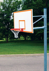 White basketball backboard with orange trim and red hoop on a gray pole, outdoors with green grass and trees.