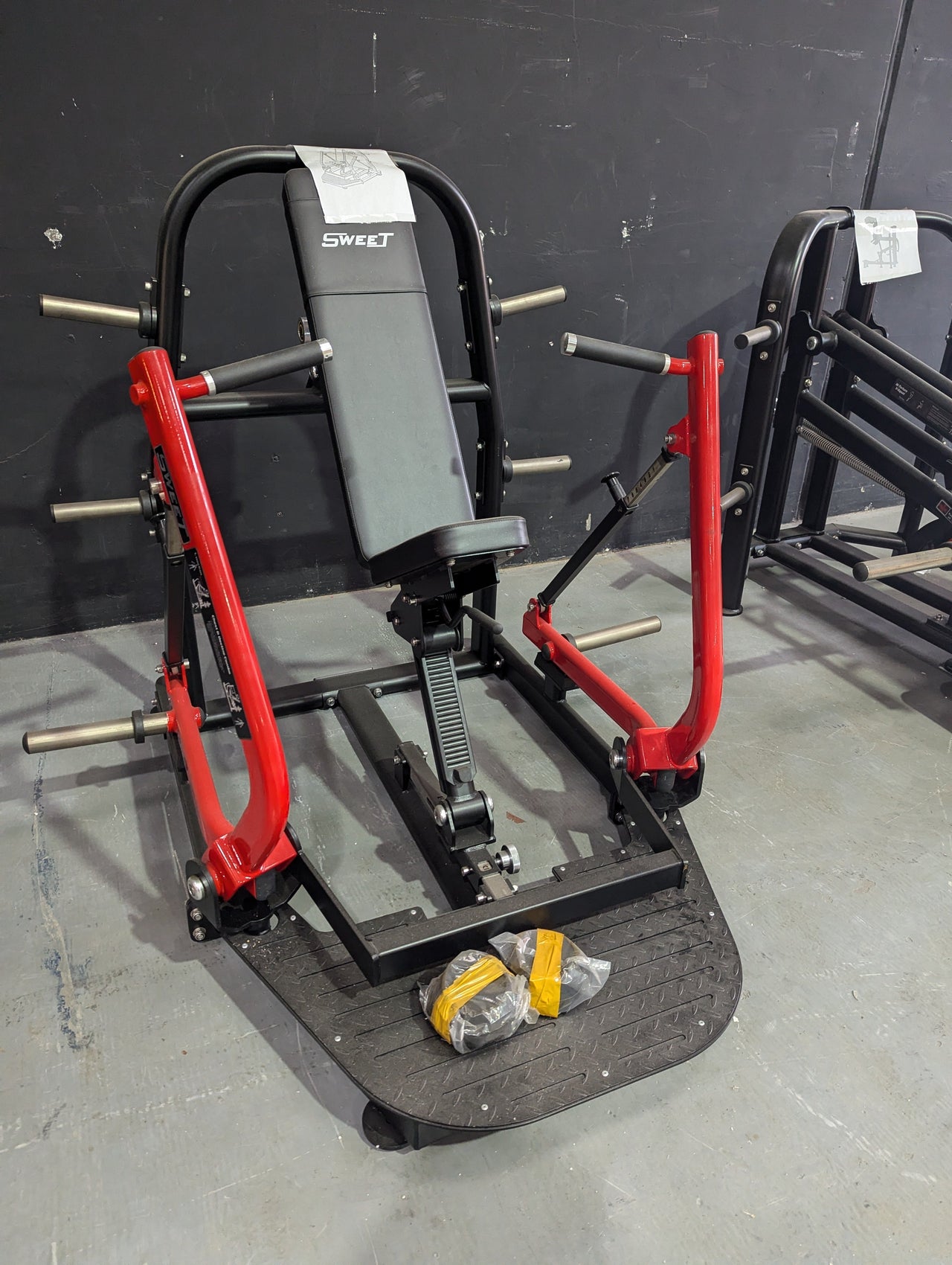 Black and red chest & decline combo gym machine with a gray padded seat and footplate.