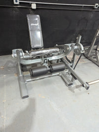 Thumbnail for Silver and black Sweet Leg Extension machine with padded seat and rollers, wrapped in plastic.