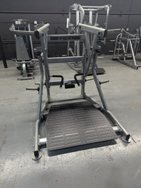 Thumbnail for Silver independent training machine with a black textured footplate and handles in a gym.