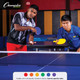 Two men playing table tennis, one with a blue paddle, the other with a yellow paddle.