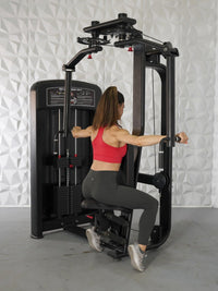 Thumbnail for Woman using a black pec deck/rear delt machine with pin selectorized weights.