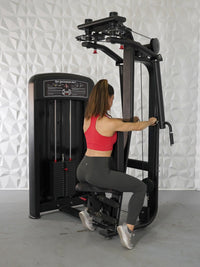 Thumbnail for Woman in red top and gray leggings using a black pec deck/rear delt machine.