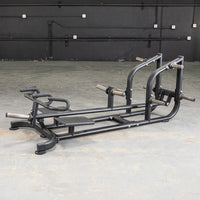 Thumbnail for Black T-bar row machine with footplates and multiple grip handles on a concrete floor.