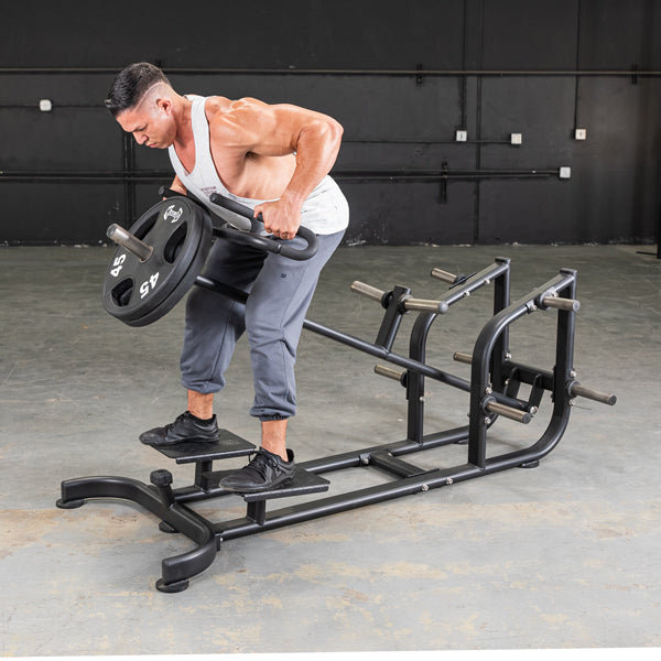 Man using a black T-bar row machine with a 45lb weight plate in a gym.