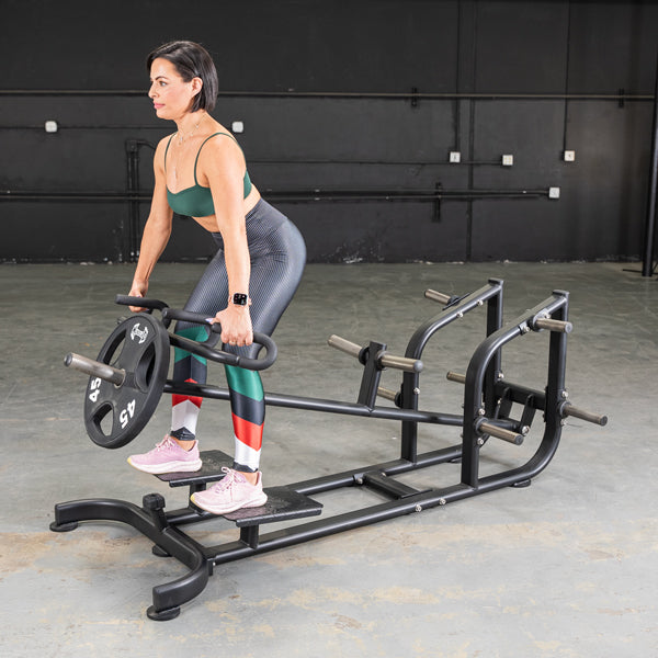 Woman performing a T-bar row exercise on a black Power Leverage V2 T-Bar Row machine with a 45lb weight plate.