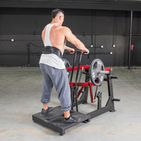 Thumbnail for Man performing belt squats on a black and red Power Leverage V2 machine with weight plates.