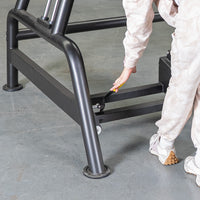 Thumbnail for A person's hand adjusting a yellow lever on the black metal frame of a fitness bench.