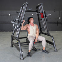 Thumbnail for Man using a black Power Leverage V2 Convergent Bench with 45lb weight plates in a gym.