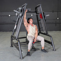 Thumbnail for Man performing shoulder press on a black weight machine with 45lb plates in a gym.