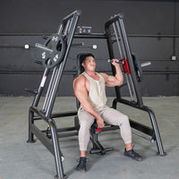 Thumbnail for Man using a black and red convergent bench press machine with weight plates in a gym.