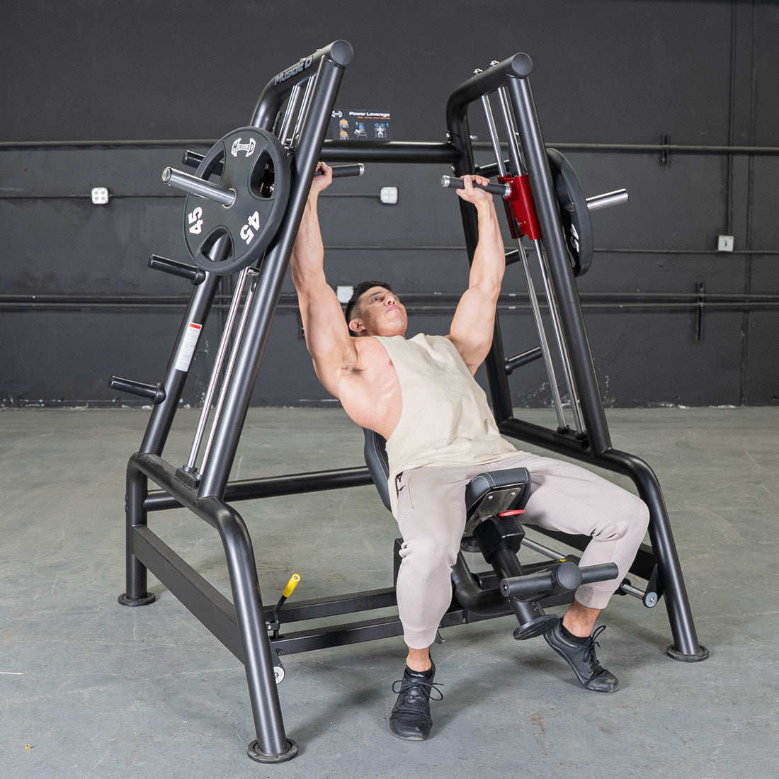 Man performing incline shoulder press on a black Power Leverage V2 Convergent Bench with 45lb plates.