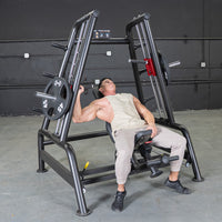 Thumbnail for Man using a black leverage bench press machine with 45lb plates in a gym.