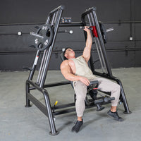 Thumbnail for Man using a black leverage bench machine for shoulder press, with weight plates on the side.
