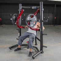Thumbnail for Man using a red and black decline chest press machine with 45lb weight plates in a gym.
