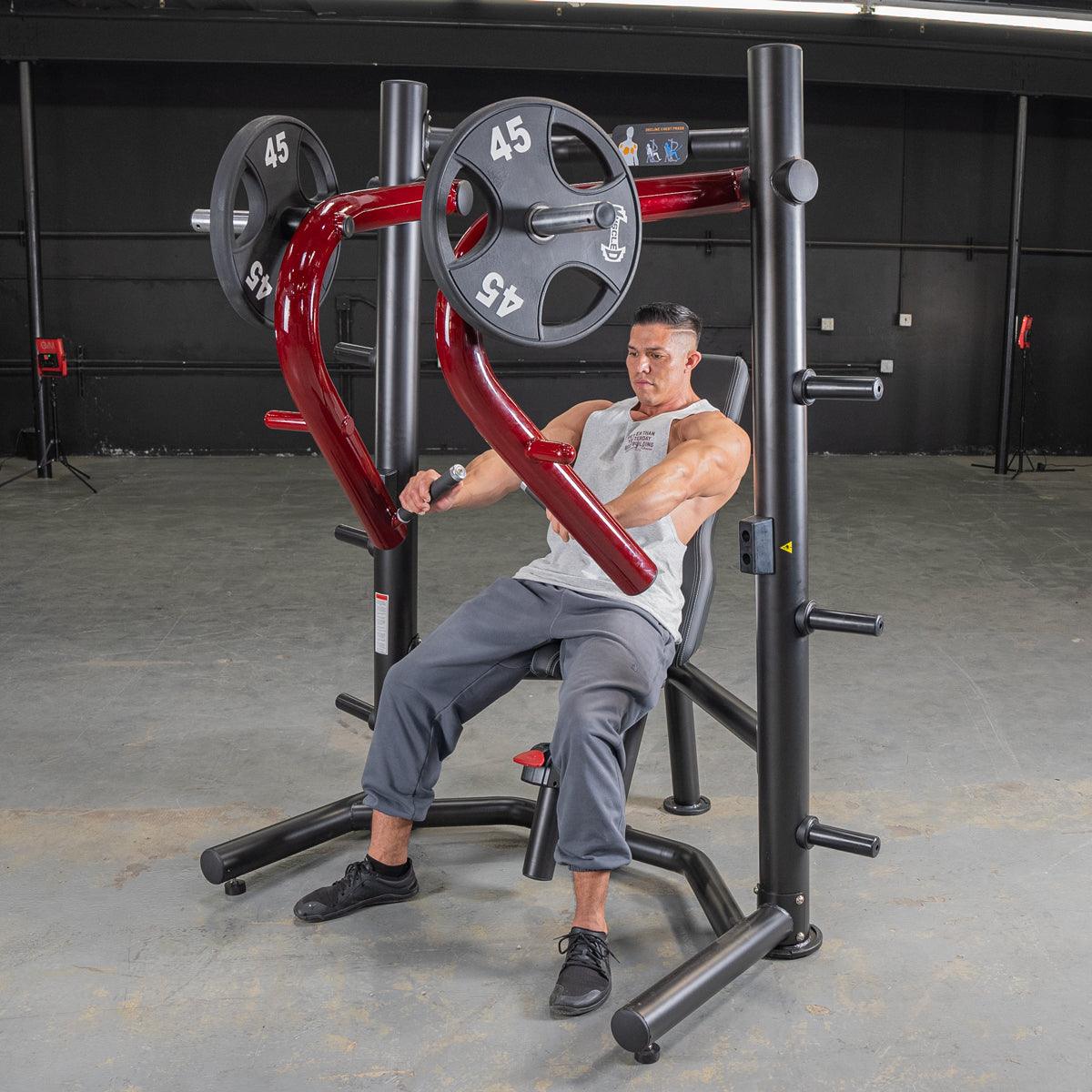 Man using a red and black decline chest press machine with 45lb weight plates in a gym.