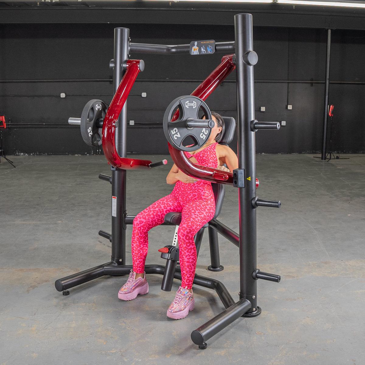 Woman in pink leopard print using a red and black decline chest press machine with 25lb weights.