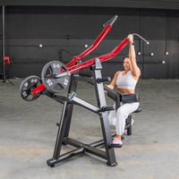 Thumbnail for Woman using a red and black iso-lateral lat pull machine with 25lb weight plates in a gym.
