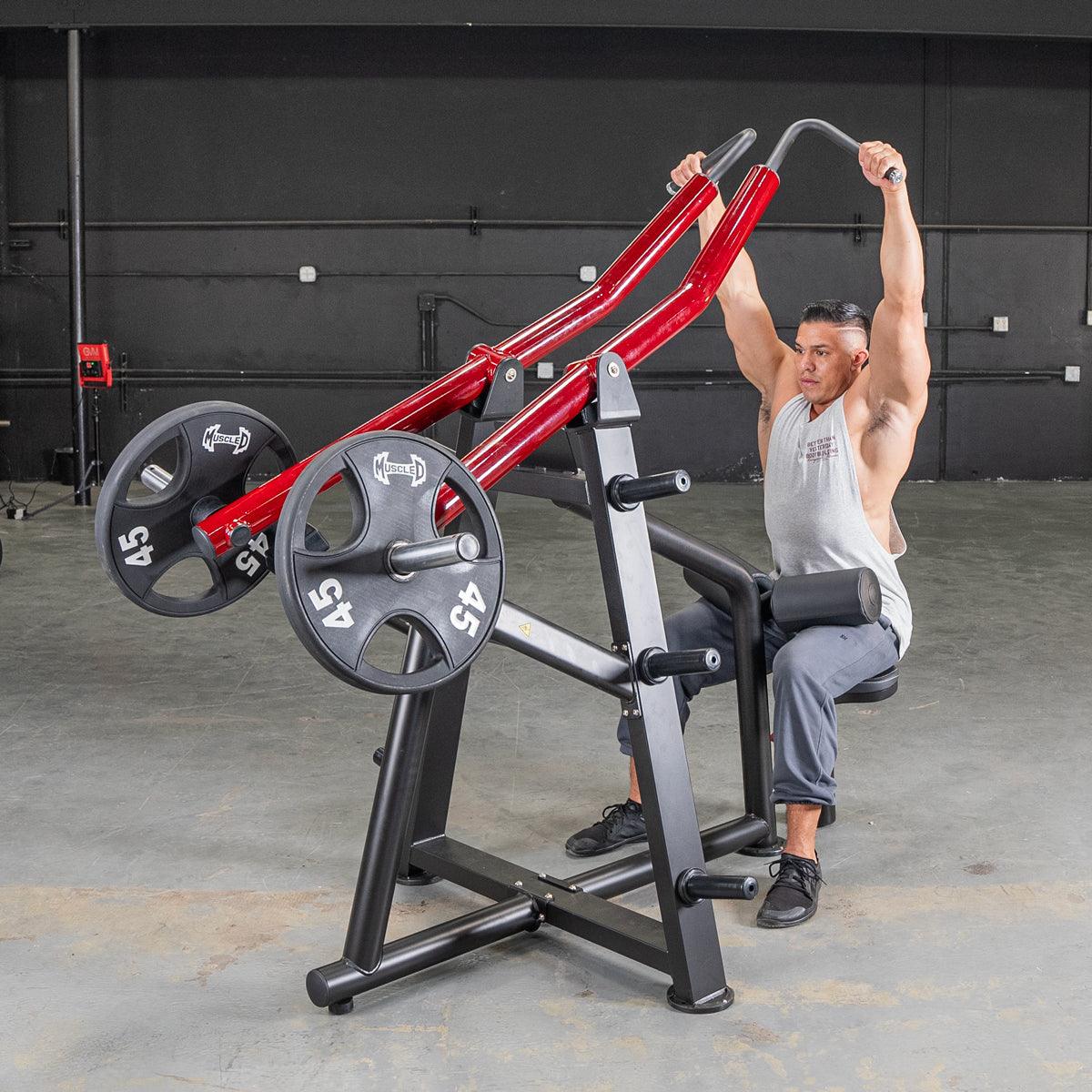 Man using a red and black iso-lateral lat pull machine with 45lb plates in a gym.