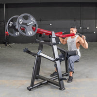 Thumbnail for Man using a red and black iso-lateral lat pull machine with 45lb weight plates in a gym.