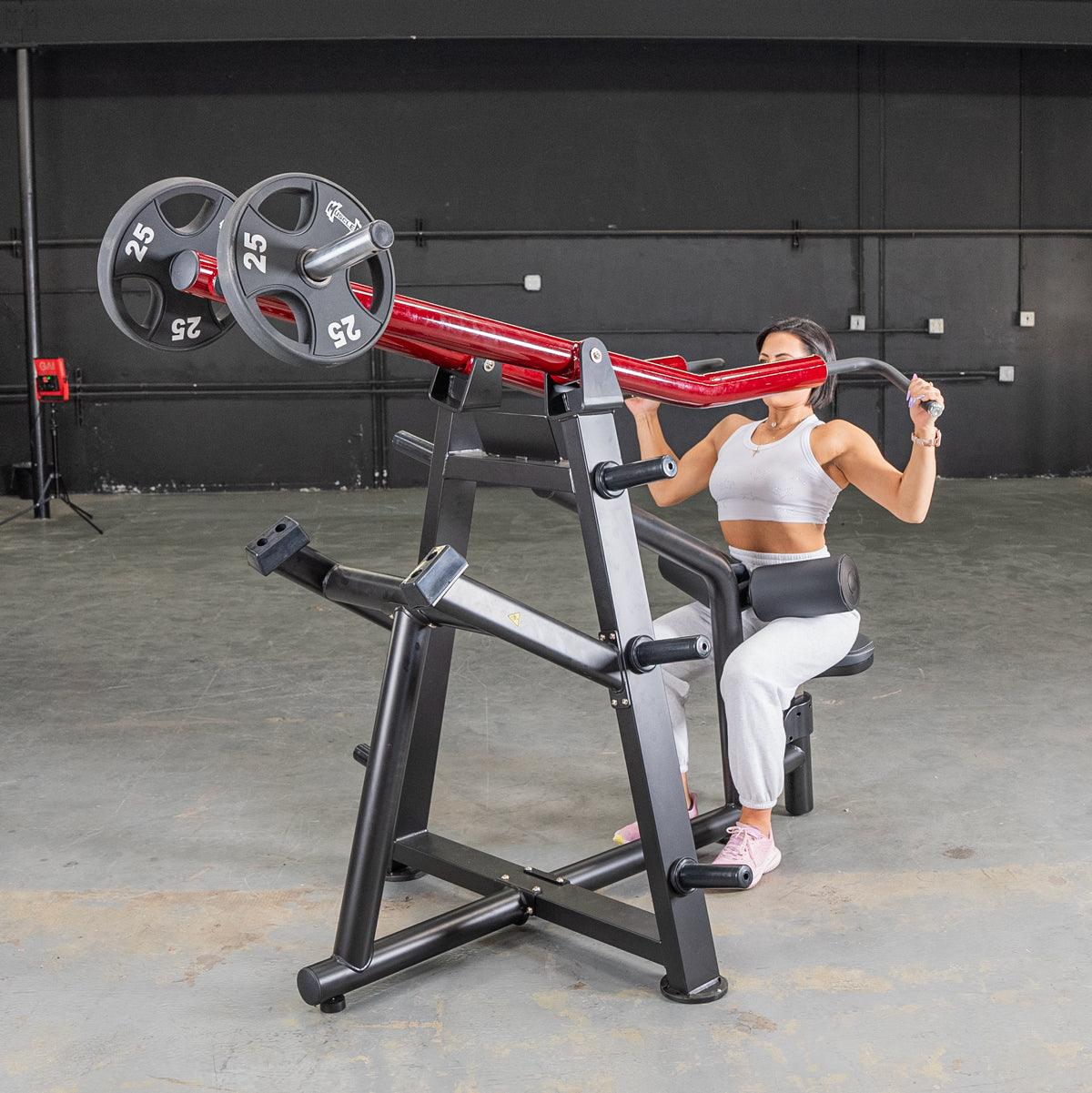 Woman using a red and black lat pull machine with two 25lb weights in a gym.