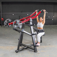 Thumbnail for Woman using a red and black iso-lateral lat pull machine with 25lb weights in a gym.