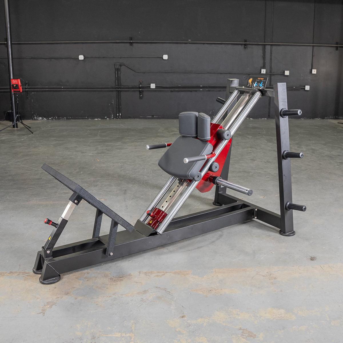 Black and red hack squat and calf raise machine with a padded seat and footplate.