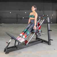 Thumbnail for Woman performing a hack squat on a black and red Power Leverage V2 machine with a 25lb weight plate.
