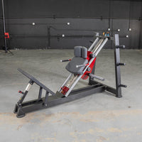 Thumbnail for Black and red hack squat and calf raise machine with a padded seat and footplate.