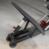 Thumbnail for Close-up of the black footplate and support structure of a hack squat machine with red adjustment knob.