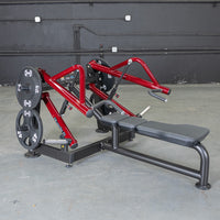 Thumbnail for Red and black horizontal chest press machine with weight plates in a gym setting.