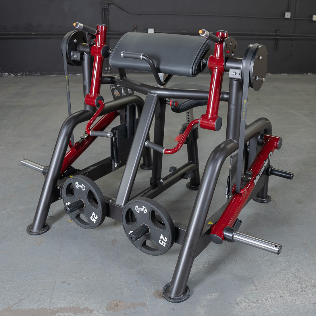 Red and black iso-lateral biceps curl machine with a padded armrest and 25lb weight plates.