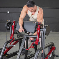 Thumbnail for Man adjusting a black and red biceps curl machine with a padded armrest.