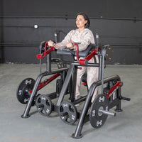 Thumbnail for Woman using a black and red biceps curl machine with weight plates in a gym.
