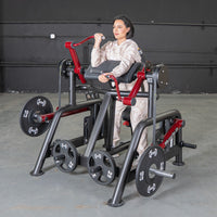 Thumbnail for Woman using a black and red iso-lateral biceps curl machine with weight plates in a gym.