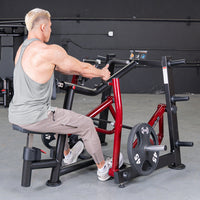 Thumbnail for Man performing a seated row exercise on a red and black iso-lateral machine with a 45lb weight plate.