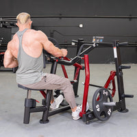 Thumbnail for Man in gray tank top using a red and black iso-lateral seated row machine in a gym.
