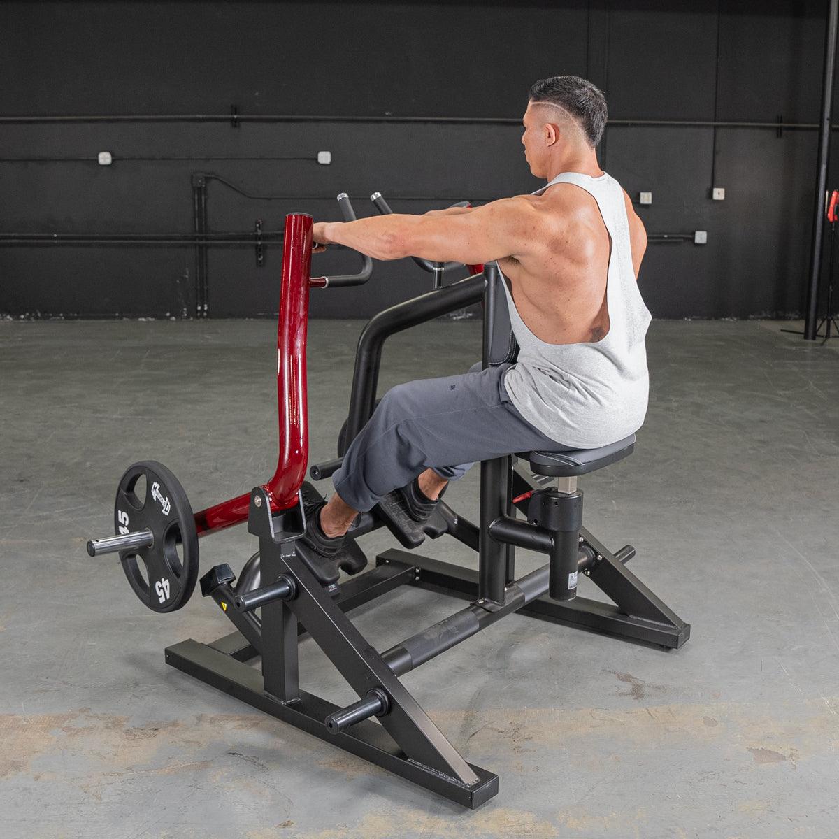 Man using a red and black seated row machine with a 45lb weight plate in a gym.