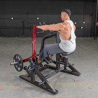 Thumbnail for Man using a red and black seated row machine with a 45lb weight plate in a gym.