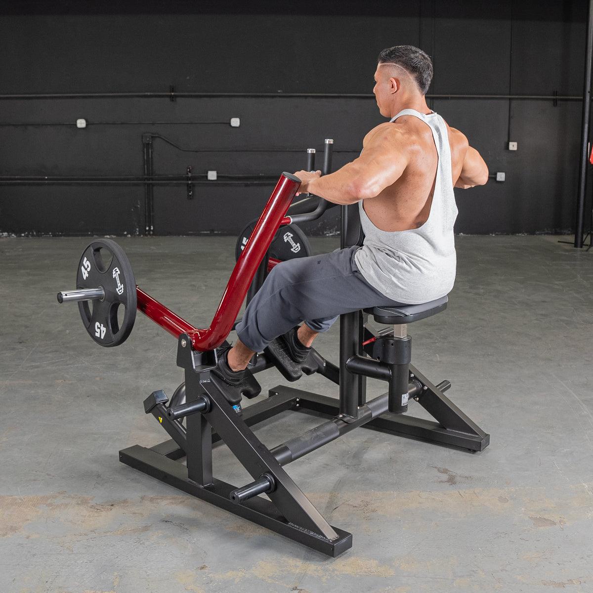 Man using a red and black iso-lateral seated row machine with a 45lb weight plate.