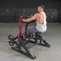 Thumbnail for Man using a red and black seated row machine with a 45lb weight plate in a gym.