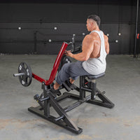 Thumbnail for Man in white tank top using a red and black seated row machine with a 45lb weight plate.