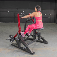 Thumbnail for Woman in pink leopard print workout gear using a red and black seated row machine with a 25lb weight plate.