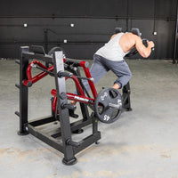 Thumbnail for Man using a red and black iso lateral sprint trainer with weight plates in a gym.