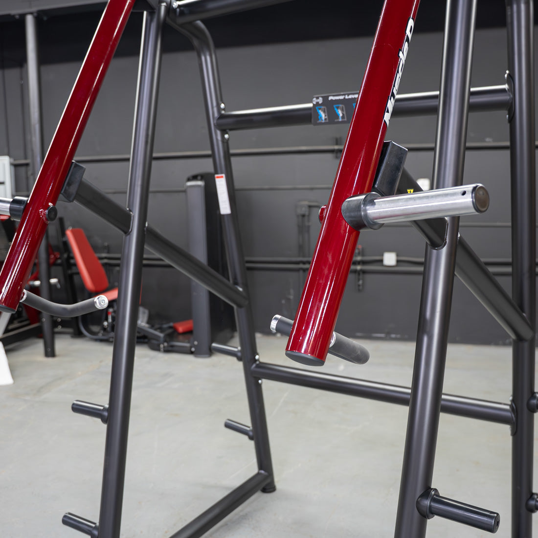 Close-up of a red and black Power Leverage V2 Jammer strength trainer in a gym.