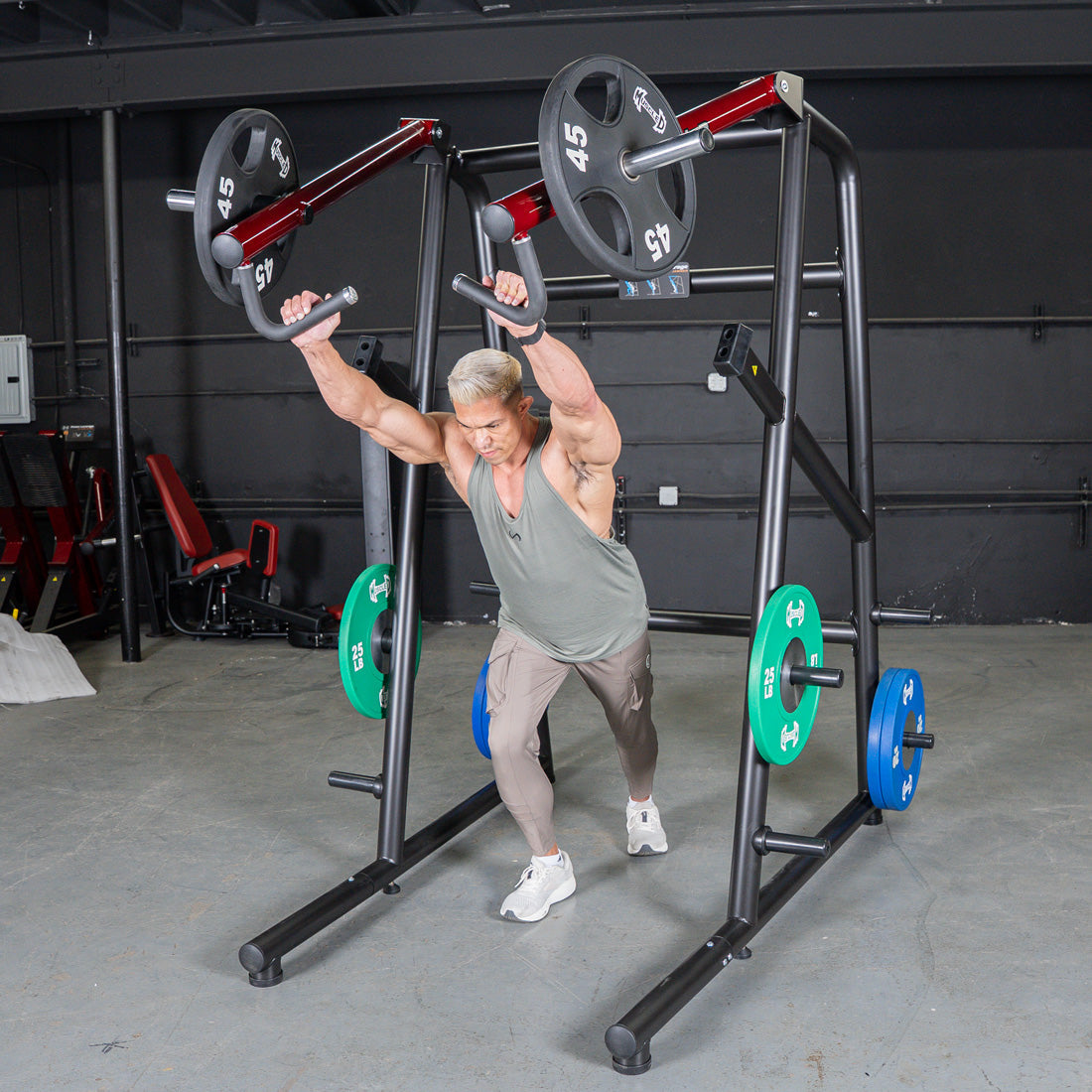 Man using a black and red jammer strength trainer with 45lb plates.
