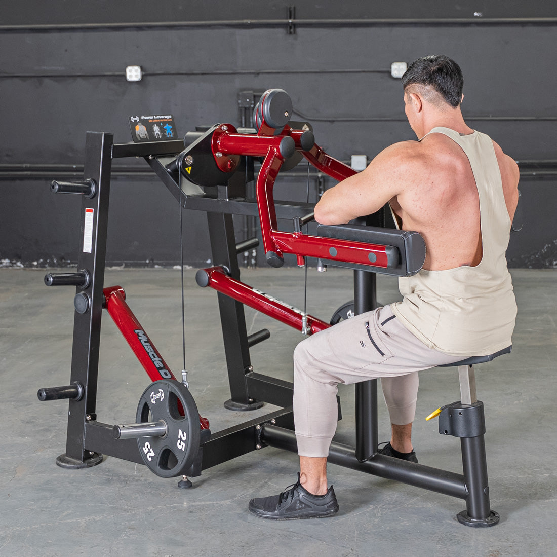 Man using a red and black Power Leverage V2 Lateral Raise machine with a 25lb weight plate.