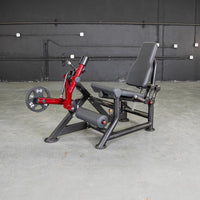 Thumbnail for Red and black leg extension machine with a 25lb weight plate on a concrete floor.