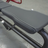 Thumbnail for Close-up of a black padded gym bench with white stitching and a black handle.