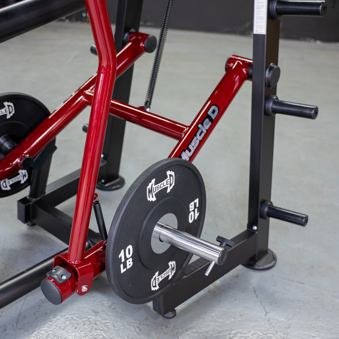 Red "Muscle D" triceps machine with a 10lb weight plate loaded on the bar.